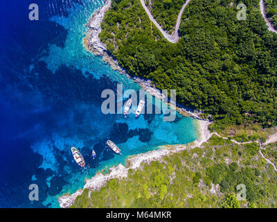 People swimming in the clear blue waters of Antipaxos Island, near Corfu - Kerkyra, Greece. Aerial view from a boat trip to the small island from Gaio Stock Photo