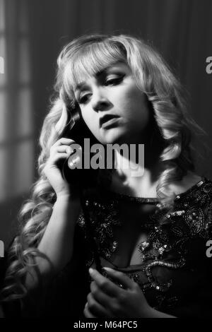 Film Noir style image of woman on telephone Stock Photo