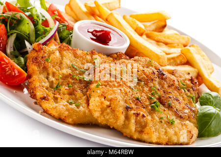 Fried pork chop, French fries and vegetables isolated on white background Stock Photo