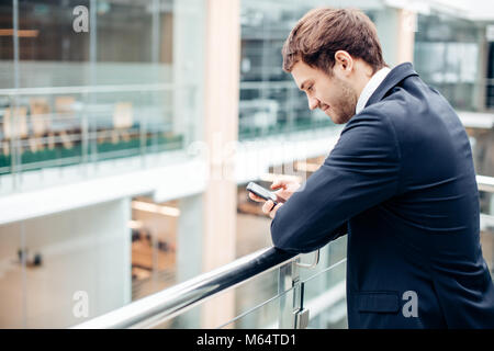 businessman with smartphone over office building Stock Photo