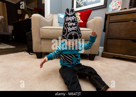 A Caucasian Boy Wears A Happy New Year Hat in His Suburban Home Living Room Stock Photo