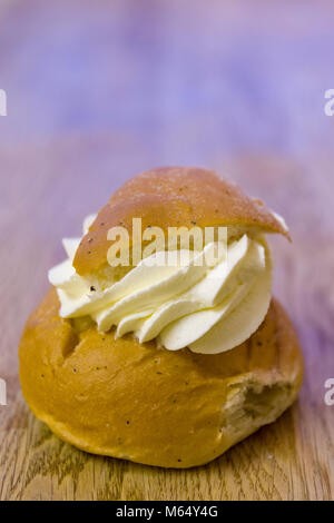 Swedish Semla – a small, wheat flour bun, flavoured with cardamom and filled with almond paste and whipped cream  Model Release: Yes/No. Property Release: Yes/No. Stock Photo