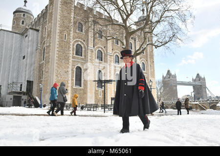 Yeoman Warder Amanda Clark walks past the White Tower at the Tower of London in snowy conditions, as the highest level of weather warning has been issued for Scotland and Ireland as forecasters warn of blizzard-like conditions. Stock Photo