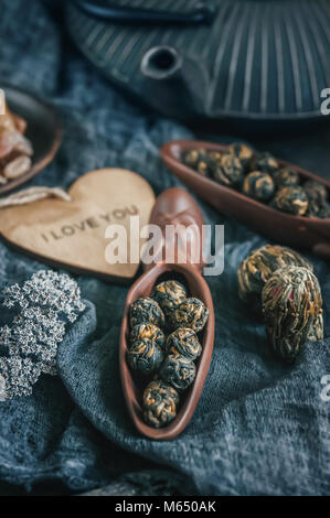 Dry black tea. Rolled leaves in a large pearl. Ceramic figural shovel with a nice flat cast-iron kettle. Chinese tea from Yunnan. Bi Lo Chun. Close up Stock Photo