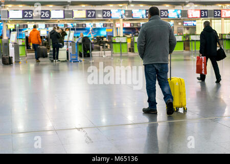 A man with a yellow suitcase at the airport goes to the terminal. Selected focus. Stock Photo