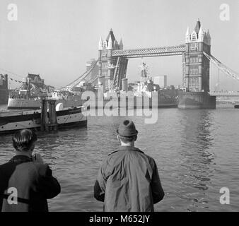 HMS Belfast, the last of the Royal Navy's big-gun cruisers, passing through Tower Bridge on her way from the King George V Dock at Greenwich to her final mooring close to Tower Bridge, where she will become a floating museum. Stock Photo