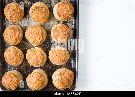 Freshly baked cheese scones on a baking tray. Stock Photo
