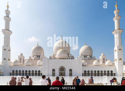 28th December 2017 - Abu Dhabi, UAE. Tourists take photographs and selfies in front of a gorgeous Sheikh Zayed mosque. Stock Photo