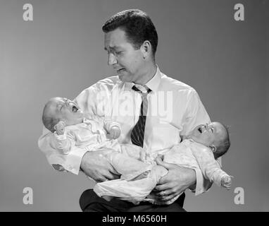 1960s PANICKED MAN FATHER HOLDING CRYING TWIN BABIES - b22022 HAR001 HARS CAUCASIAN SONS DOUBLE LIFESTYLE PARENTING BROTHERS STUDIO SHOT HEALTHINESS HOME LIFE COPY SPACE HALF-LENGTH CARING CRY INDOORS SIBLINGS NOSTALGIA FATHERS TOGETHERNESS 25-30 YEARS 30-35 YEARS SAME YOUNGSTER DADS SUPPORT GROWTH SIBLING PEOPLE BABIES SMALL GROUP OF PEOPLE BABY BOY 1-6 MONTHS JUVENILES MALES MID-ADULT MID-ADULT MAN B&W BLACK AND WHITE CAUCASIAN ETHNICITY OLD FASHIONED PERSONS Stock Photo