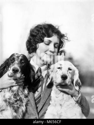1920s WOMAN HOLDING PETTING TWO ENGLISH SETTER DOGS OUTDOORS - d2099 HAR001 HARS TOGETHERNESS 20-25 YEARS 25-30 YEARS HAPPINESS TWO ANIMALS HEAD AND SHOULDERS RECREATION PETTING CONNECTION ANIMALS DOGS CANINE CREATURE MID-ADULT WOMAN SETTER B&W BLACK AND WHITE CAUCASIAN ETHNICITY COMPANIONS COMPANIONSHIP OLD FASHIONED Stock Photo