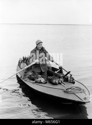 1950s MAN DUCK HUNTER WITH HARVEST ROWING BARNEGAT BAY SNEAK BOX BOAT NEW JERSEY USA - d3802 HAR001 HARS ANIMALS HUNTER DEAD NOSTALGIA HUNT 30-35 YEARS 35-40 YEARS HISTORIC SUCCESS OLDSTERS HIGH ANGLE OLDSTER ADVENTURE EXCITEMENT RECREATION DECOY NJ ELDERS DECOYS NEW JERSEY BARNEGAT MALES MID-ADULT MID-ADULT MAN SNEAK SNEAKBOX B&W BARNEGAT BAY BLACK AND WHITE CAUCASIAN ETHNICITY DUCK HUNTER OLD FASHIONED PERSONS SNEAK BOX Stock Photo