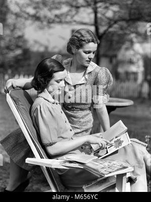 1930s TWO WOMEN IN BACKYARD ONE SITTING IN LAWN CHAIR OTHER LOOKING OVER SHOULDER READING PLANT SEED CATALOGS - g4458 HAR001 HARS CAUCASIAN LIFESTYLE FEMALES GROWNUP HOME LIFE COPY SPACE FRIENDSHIP HALF-LENGTH LADIES GROWN-UP SIBLINGS SISTERS NOSTALGIA TOGETHERNESS 20-25 YEARS BRUNETTE DREAMS RELAXATION CHOICE RECREATION 18-19 YEARS GROWTH SEED SIBLING COOPERATION LAWN CHAIR MID-ADULT WOMAN YOUNG ADULT WOMAN B&W BLACK AND WHITE CATALOGS CAUCASIAN ETHNICITY CHOOSING OLD FASHIONED PERSONS Stock Photo