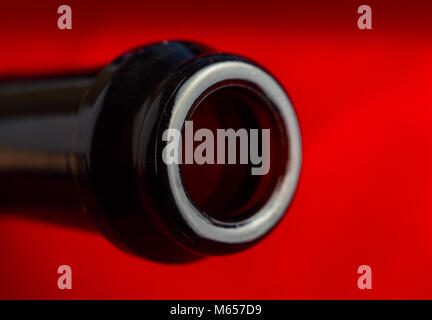 Neck of Champagne bottle on red background, top view, macro, close up. Stock Photo