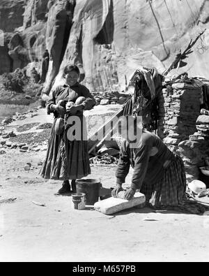 1930s TWO NATIVE AMERICAN NAVAJO INDIAN WOMEN GRINDING CORN AND HARVESTING SQUASH CANYON DEL MUERTO ARIZONA USA - i2038 HAR001 HARS LADIES DAUGHTERS INDIANS NAVAJO SIBLINGS SISTERS NOSTALGIA NORTH AMERICA 25-30 YEARS 30-35 YEARS HARVESTING HISTORIC NORTH AMERICAN MANUAL MOMS KNOWLEDGE SIBLING ARIZONA NATIVE AMERICAN GRINDSTONE JUVENILES MID-ADULT MID-ADULT WOMAN B&W BLACK AND WHITE CANYON DEL MUERTO GRINDING INDIGENOUS MANUALLY MILLING OLD FASHIONED PERSONS Stock Photo