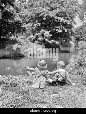 1940s 1950s GIRL BOY SITTING IN GRASS BESIDE POND STREAM SISTER POINTING ARM ON BROTHERS SHOULDER SUMMERTIME - j10641 HAR001 HARS HALF-LENGTH STREAM SIBLINGS SISTERS NOSTALGIA SUMMERTIME 3-4 YEARS 5-6 YEARS HAPPINESS REAR VIEW GROWTH SIBLING BESIDE BACK VIEW JUVENILES MALES B&W BLACK AND WHITE CAUCASIAN ETHNICITY OLD FASHIONED Stock Photo