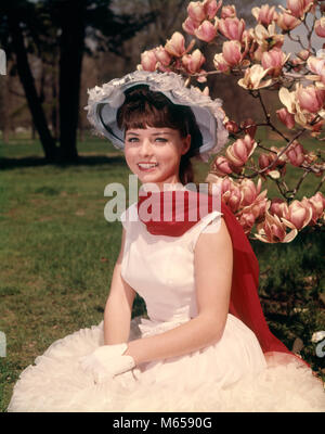 1960s YOUNG WOMAN SITTING BY BLOSSOMING MAGNOLIA TREE WEARING SPRINGTIME HAT RED SCARF WHITE GLOVES AND DRESS LOOKING AT CAMERA - kb5213 HAR001 HARS STYLISH SUBURBAN SPRING COLOR OLD TIME FIGURES OLD FASHION 1 JUVENILE STYLE YOUNG ADULT CAUCASIAN PLEASED JOY LIFESTYLE BEAUTIFUL FEMALES GROWNUP HEALTHINESS ONE PERSON ONLY COPY SPACE FULL-LENGTH HALF-LENGTH LADIES INSPIRATION SIT GROWN-UP TEENAGE GIRL SERENITY NOSTALGIA EYE CONTACT 16-17 YEARS 20-25 YEARS BRUNETTE YOUNGSTER HAPPINESS CHEERFUL LEISURE RELAXATION BLOSSOM 18-19 YEARS POSING SMILES JOYFUL TEENAGED HEAD-WARE SOUTHERN BELLE BLOSSOMS Stock Photo