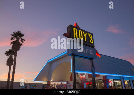 Neon-lit 'Roy's Café' sign with diner in Barstow, California. Stock Photo