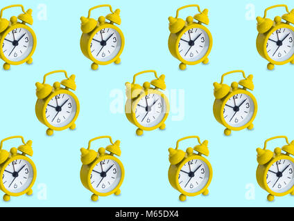 Seamless pattern made of golden analogue clocks in isolated blue pastel background. Stock Photo