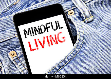Handwriting Announcement text showing Mindful Living. Business concept for Life Happy Awareness Written phone mobile phone, cellphone placed in man fr Stock Photo