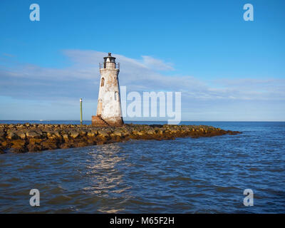 The Cockspur Island Lighthouse on a point of rocky land on the river in Fort Pulaski National Monument near Savannah, Georgia and Tybee Island, GA. Stock Photo