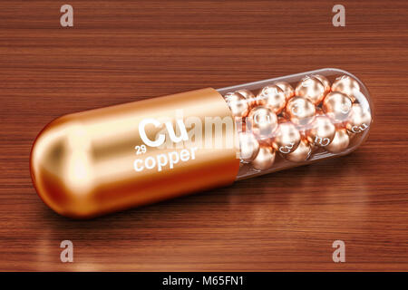 Capsule with copper Cu element on the wooden table. 3D rendering Stock Photo