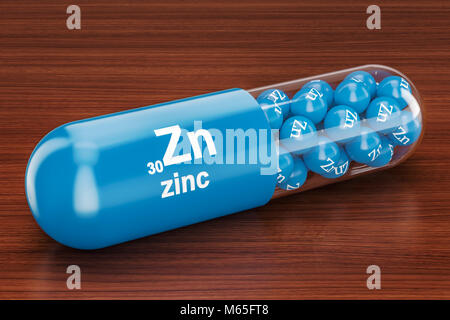 Capsule with zinc Zn element on the wooden table. 3D rendering Stock Photo