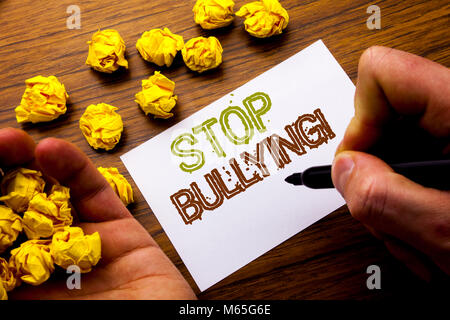 Word, writing Stop Bullying. Concept for Prevention Problem Bully written on notebook note paper on wooden background with folded paper meaning thinki Stock Photo