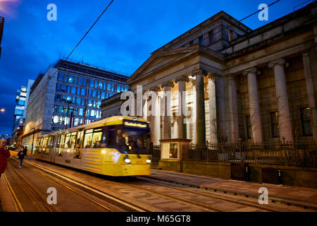 At night a Metrolink tram passing Manchester Art Gallery on Lower Mosley Street Stock Photo