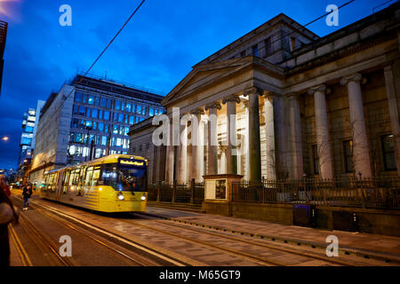 At night a Metrolink tram passing Manchester Art Gallery on Lower Mosley Street Stock Photo