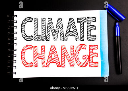 Handwritten text showing Climate Change. Business concept writing for Global Planet Warming Written on notepad paper, black background with space offi Stock Photo