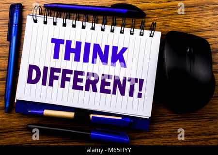 Handwritten text showing Think Different. Business concept for Outside Box Creative written on notebook book note paper on wooden background. Blue wor Stock Photo