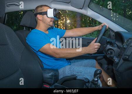 Young male driver using virtual reality glasses in car interior Stock Photo