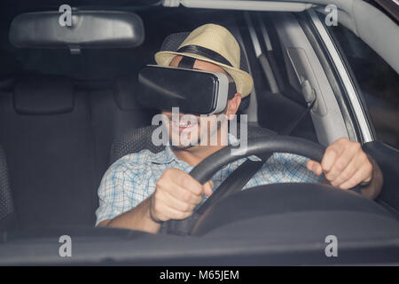 Young driver sitting in car and using virtual reality glasses simulation app Stock Photo