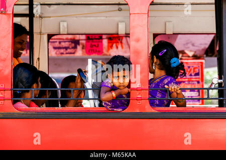A young boy looking out curiously from a local bus in Munnar, in Kerala, India. Stock Photo