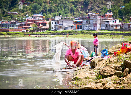 POKHARA,NEPAL-MAY 25:Family washing cloth in Fewa lake on May 25, 2013, Pokhara,Nepal.One of the most beautiful Lakes of Pokhara Valley is the well-kn Stock Photo