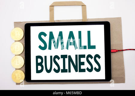 Handwritten text showing Small Business. Business concept writing for Strategy Management Written on shopping bag and tablet white background, tablet  Stock Photo