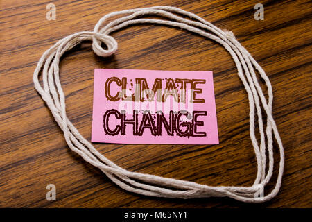 Handwritten text showing Climate Change. Business concept for Global Planet Warming written on sticky note paper on dark wooden background. With heart Stock Photo