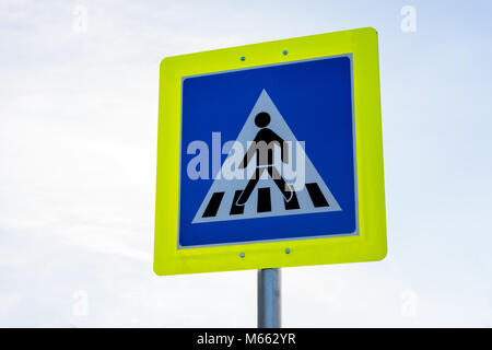 Pedestrian crossing road safety traffic sign in yellow frame on white sky Stock Photo
