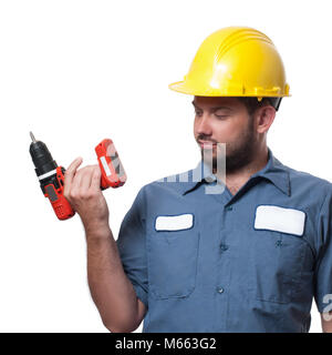 Contractor. Man in uniform and yellow helmet with drill Stock Photo