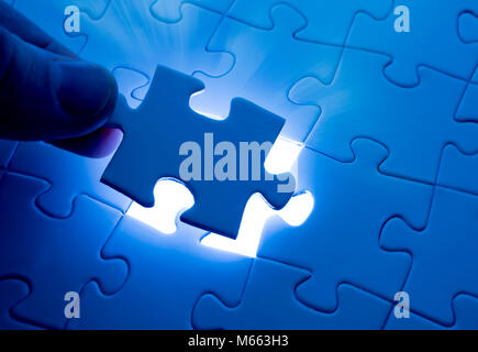 Placing last piece of jigsaw puzzle Stock Photo