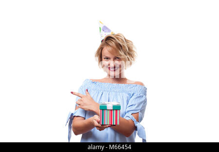 Beautiful happy woman in a celebratory cap with gift box at celebration party. Birthday celebrating concept Stock Photo