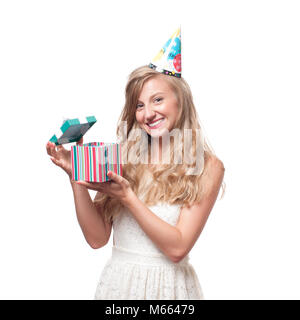 Beautiful happy girl in a celebratory cap with gift box at celebration party. Birthday celebrating concept Stock Photo