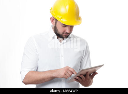 Contractor in yellow helmet working on a project with tablet. Architect in builder helmet. Stock Photo
