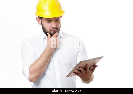 Contractor in yellow helmet working on a project with tablet. Architect in builder helmet. Stock Photo