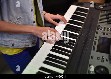 Woman plays on electric piano (hands and keyboard closeup) Stock Photo