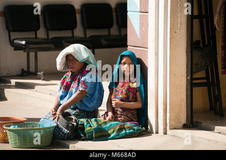 An indigenous K'iche' (Quiché) Maya woman and her daughter selling food in the market. Santa Cruz del Quiché, Guatemala. Stock Photo