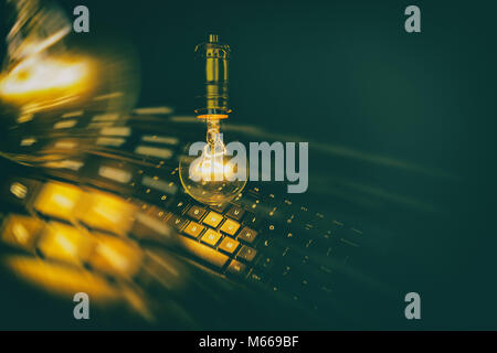 Light bulb and computer keyboard, concept of wisdom. Stock Photo