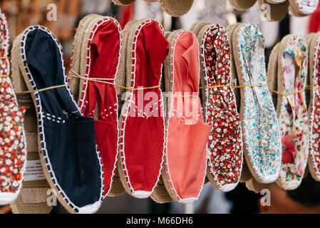 Colorful spanish handmade rope soled sandals or espadrilles in market stall Stock Photo