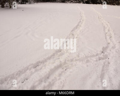 field covered in snow with two tracks through it landscape texture terrain; essex; england; uk Stock Photo