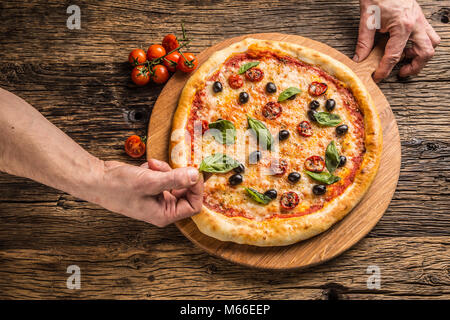 Chef and pizza. Phef preparing pizza in hotel or restaurant. Stock Photo